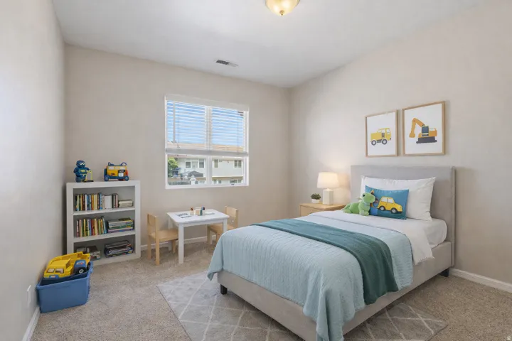 Neutral-toned walls, carpeted flooring, and a large window with blinds