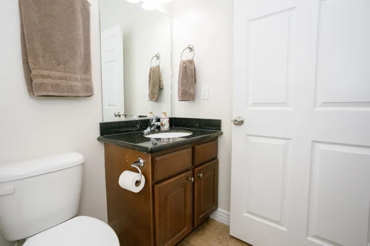 Dark wood-finish vanity with a dark countertop and undermount sink