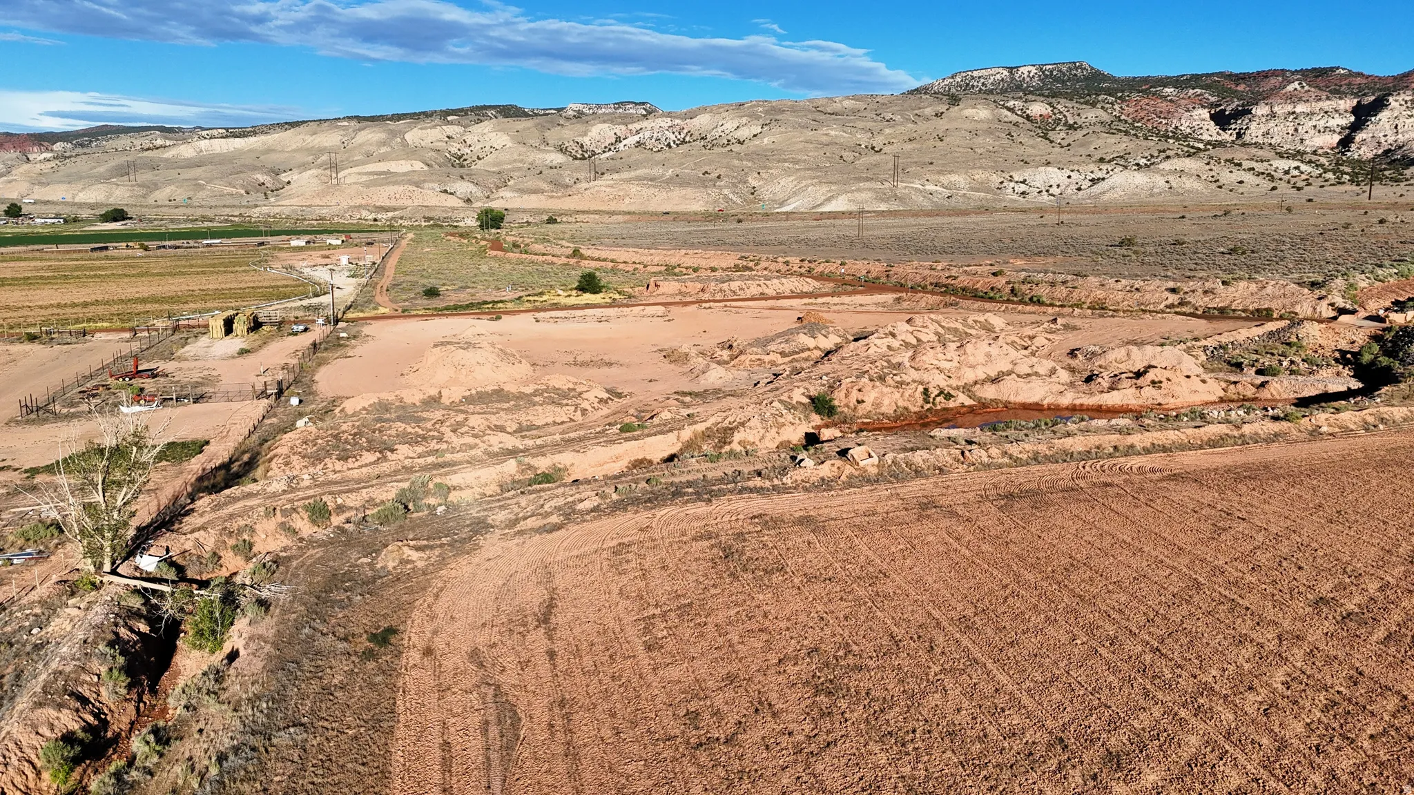 Expansive open land featuring diverse terrain and distant mountainous backdrop