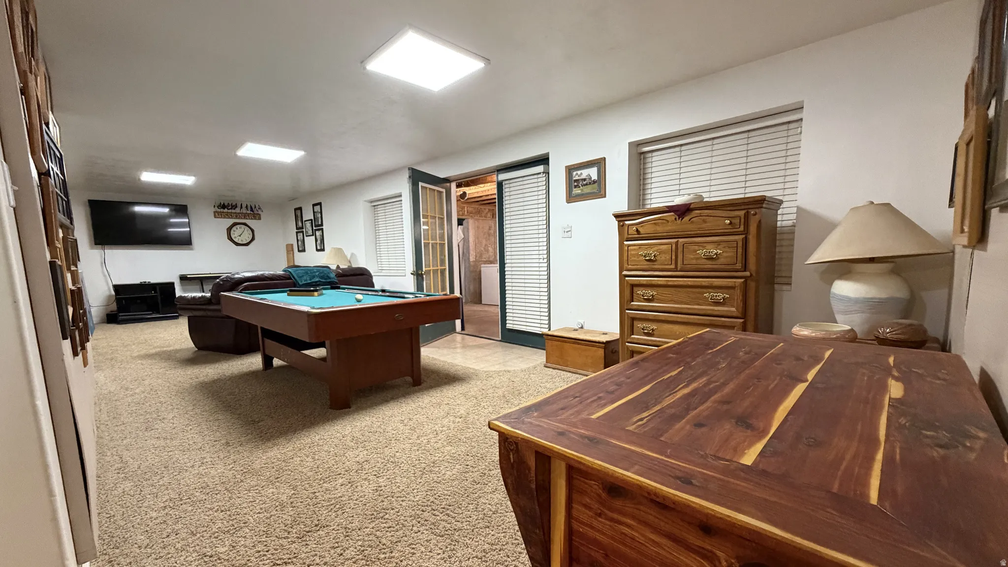 Carpeted room with recessed lighting and a window with blinds