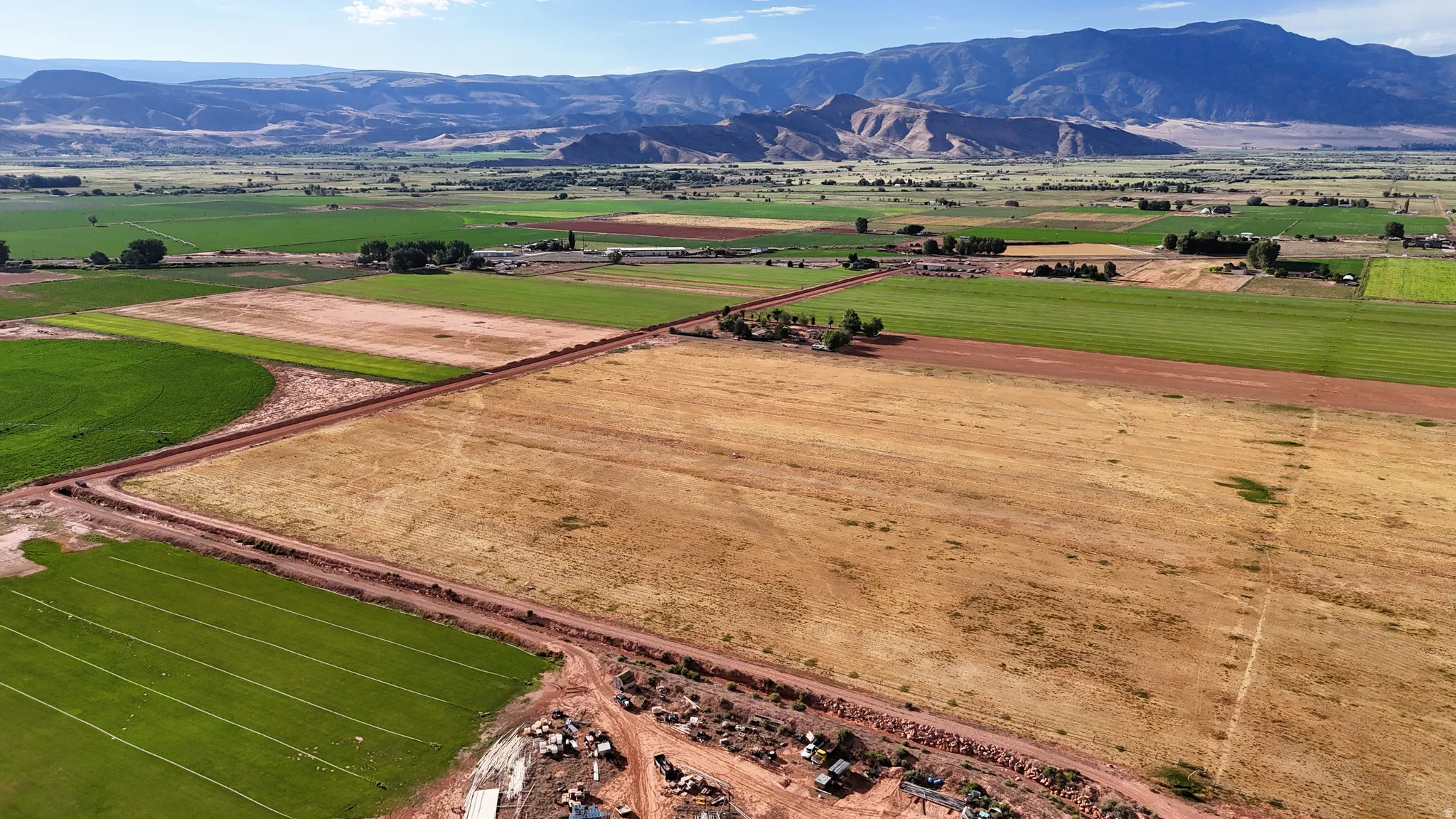Expansive agricultural land featuring cultivated fields and a distant mountain range