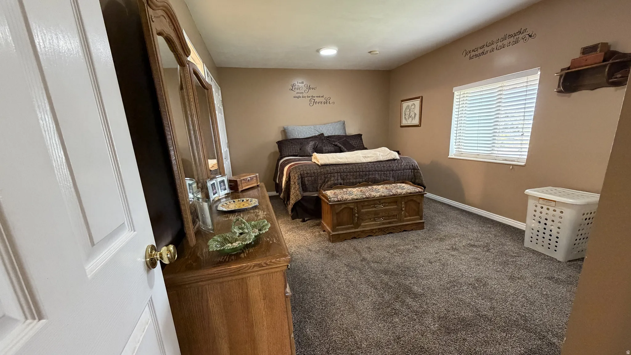 Wall-to-wall carpeting in a neutral tone, recessed ceiling lighting, and a window with horizontal blinds
