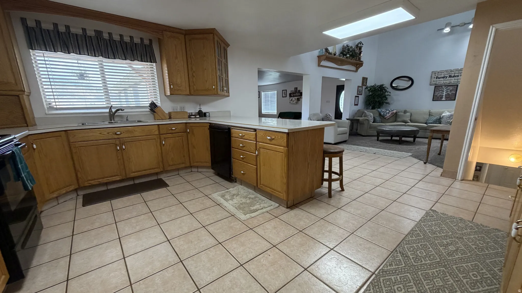 Kitchen featuring wood-finish cabinetry, light-toned countertops, and tile flooring