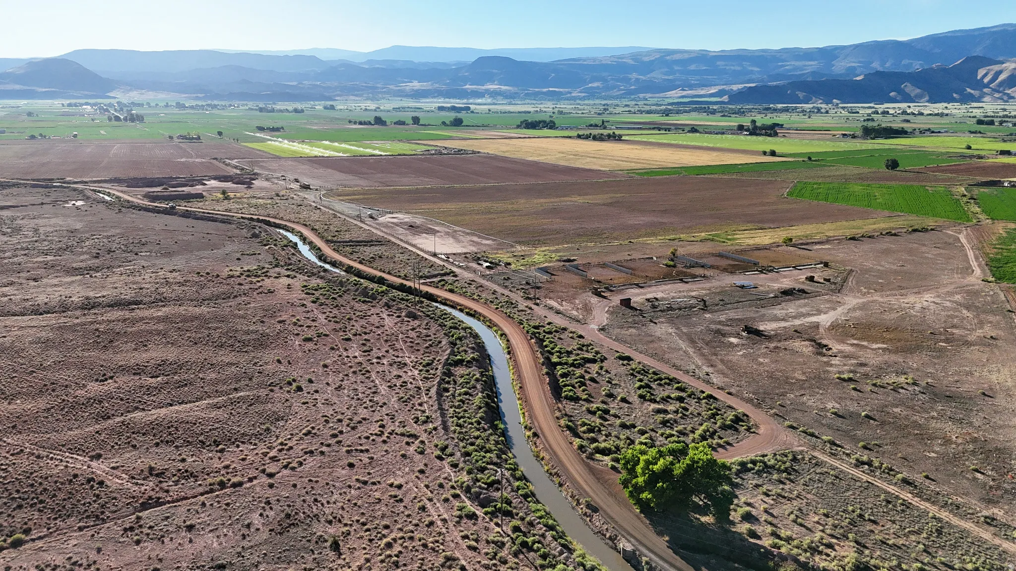 Expansive land parcel with surrounding agricultural fields and distant mountains