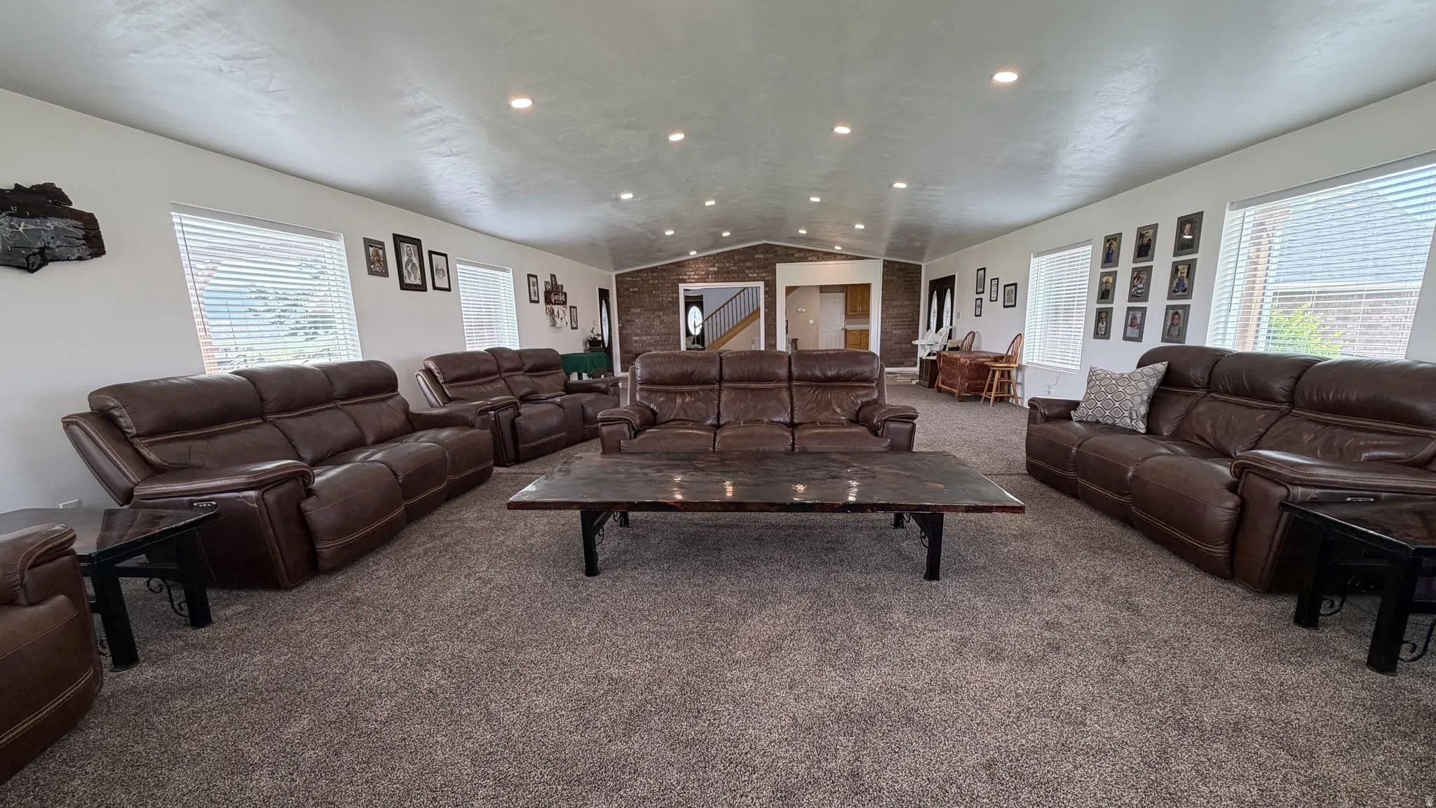 Spacious room with recessed lighting, multiple windows, and textured carpet flooring