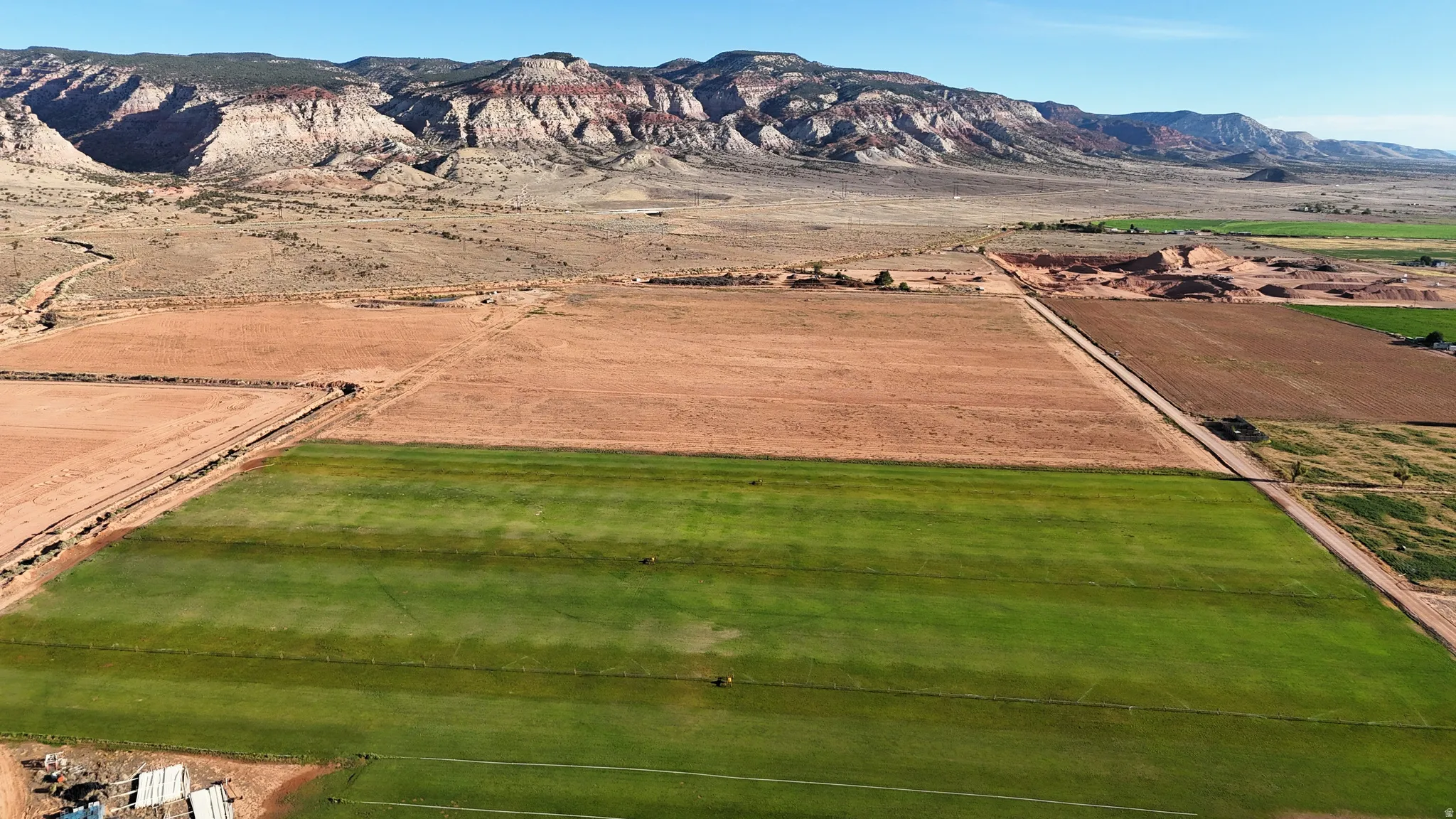 Expansive agricultural land featuring cultivated fields and a distant mountain range