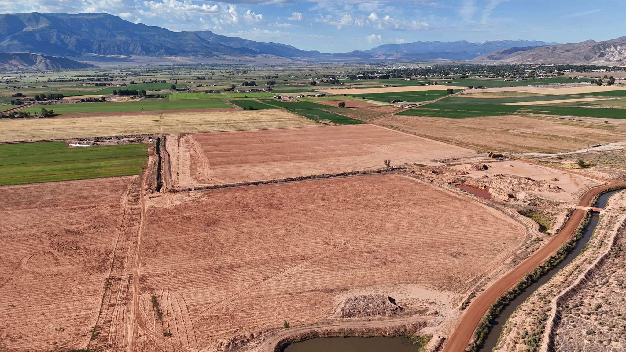 Expansive land parcel with visible tilled earth and agricultural fields
