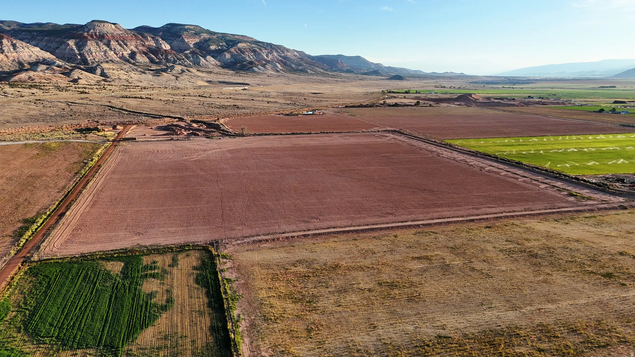 Expansive agricultural land featuring cultivated fields and natural terrain