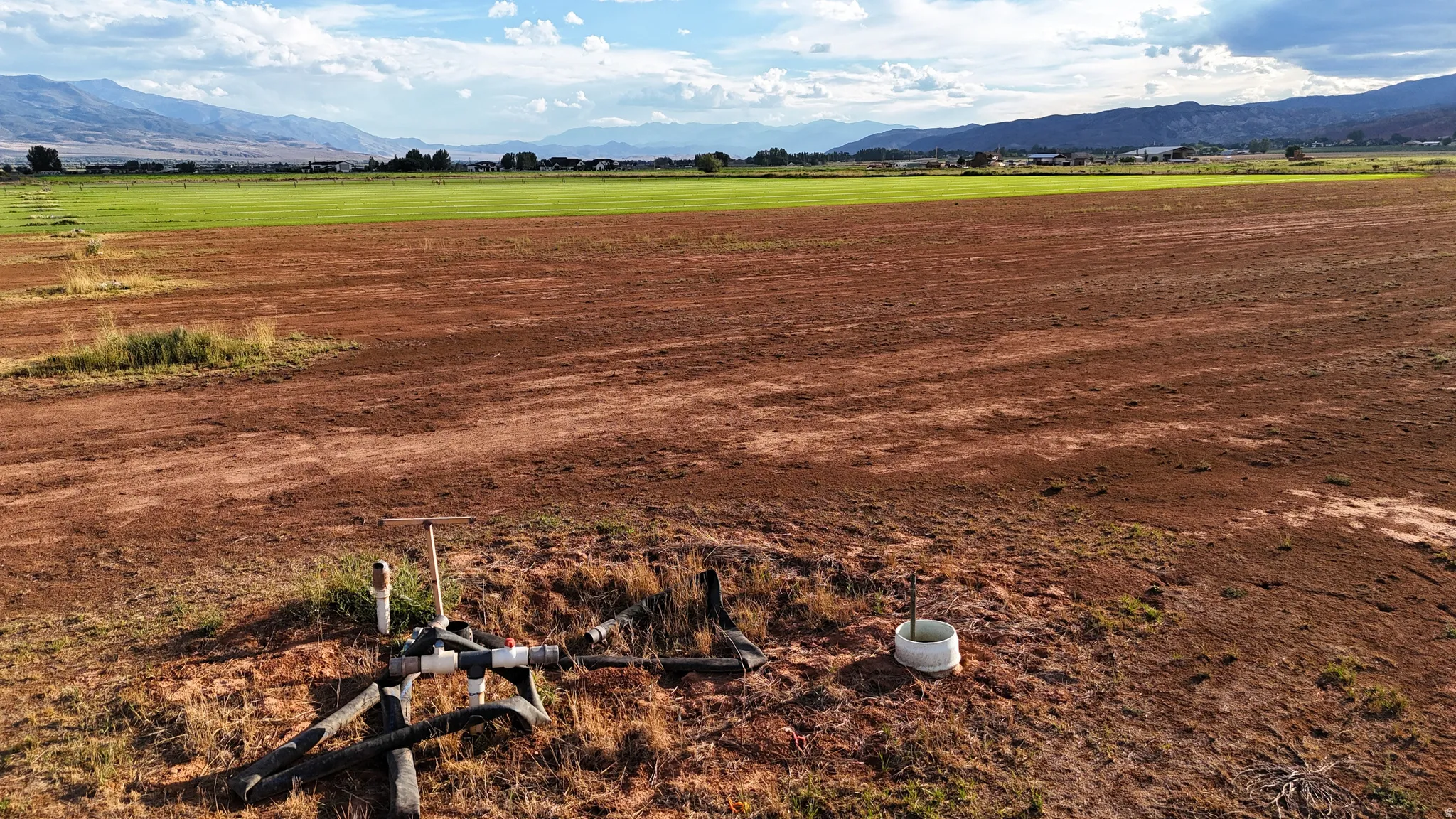 Expansive agricultural land featuring a large open field and irrigation infrastructure