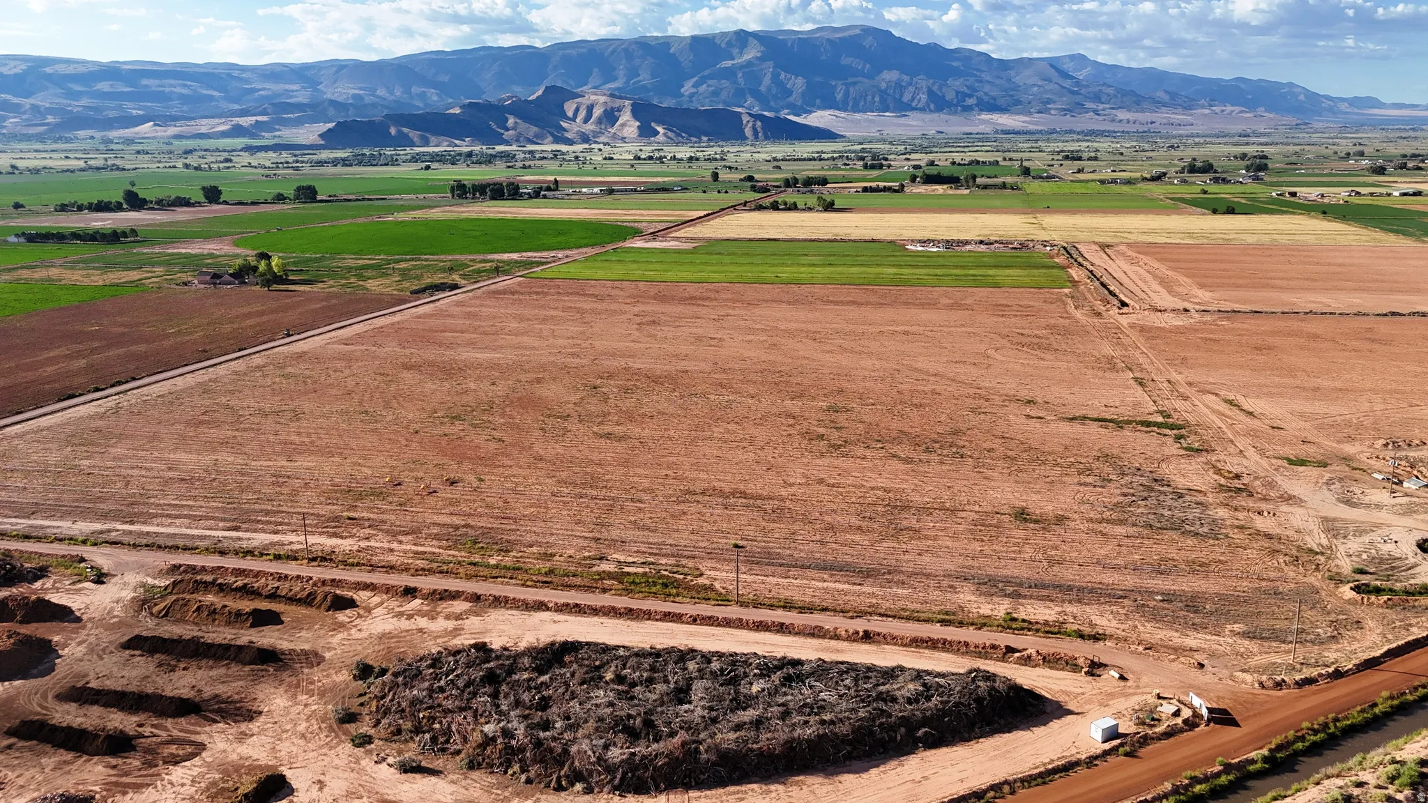 Expansive agricultural land featuring cultivated fields and distant mountain ranges