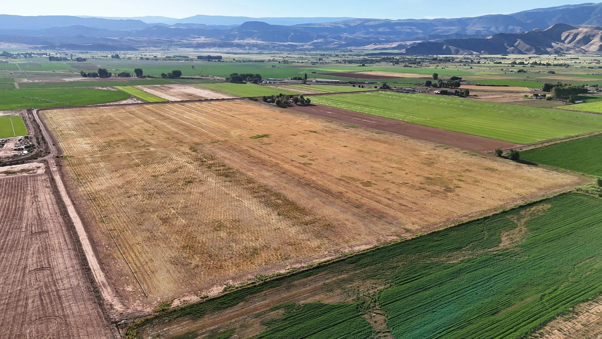 Expansive agricultural acreage with cultivated fields and distant mountain ranges