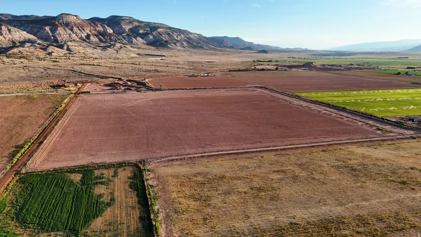 Expansive agricultural land featuring cultivated fields and natural terrain