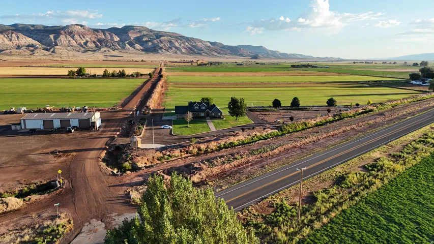Expansive rural property featuring a main residence, paved road frontage, and a large outbuilding
