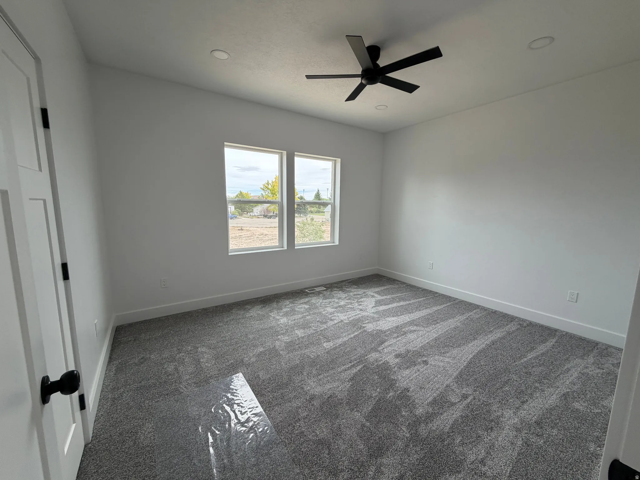 Bedroom 1 Two windows, recessed lighting, and a ceiling fan with matte black blades