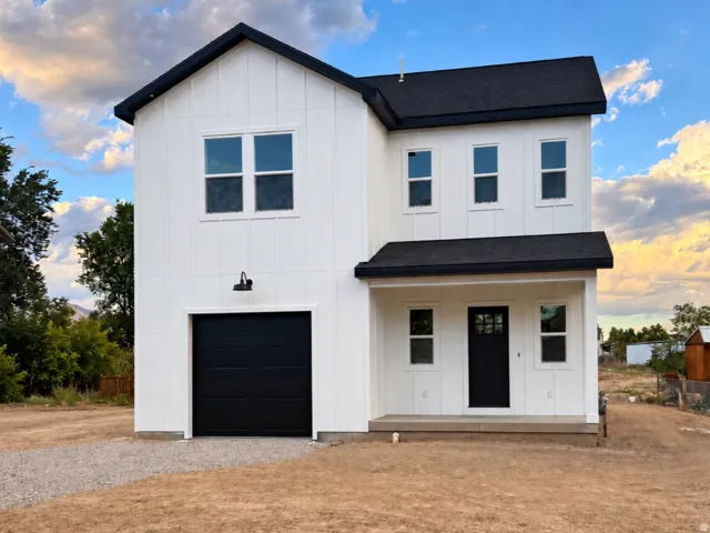 Two-story exterior with white vertical siding and contrasting black trim