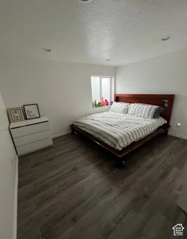 Wood-finish flooring throughout, recessed ceiling lighting, and a window with privacy blinds