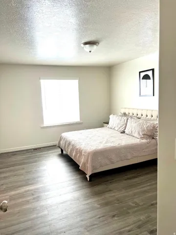 Wood-finish flooring, neutral wall tones, and overhead flush-mount lighting