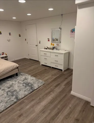 Recessed lighting, wood-finish flooring, white walls, and white baseboards
