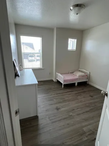 Wood-finish flooring throughout, multiple windows, and a flush mount ceiling light fixture