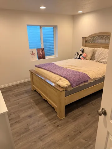 Recessed ceiling lighting illuminates the room with wood-finish flooring