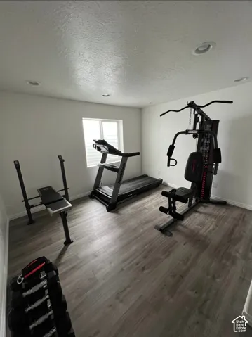 Recessed lighting, wood-finish flooring, and a window with blinds