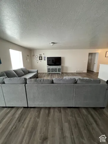 Wood-finish flooring throughout, light-toned walls, and a large window providing ambient light