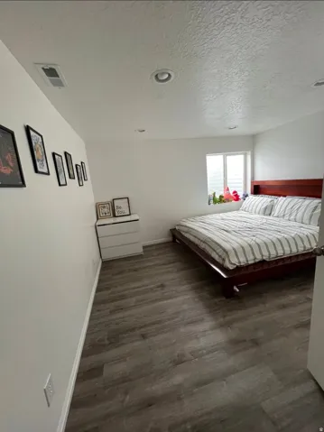 Wood-finish flooring, recessed lighting, and a window with horizontal blinds