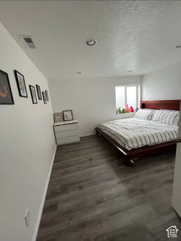 Wood-finish flooring, recessed lighting, and a window with horizontal blinds