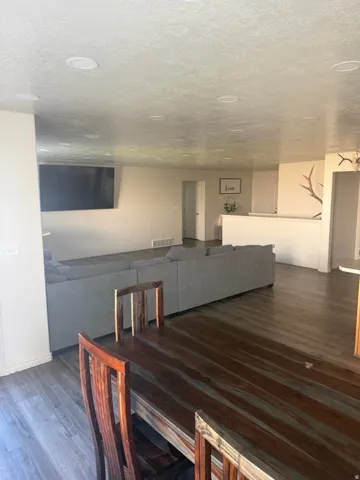 Recessed lighting, wood-finish flooring, and a partial wall with a cap