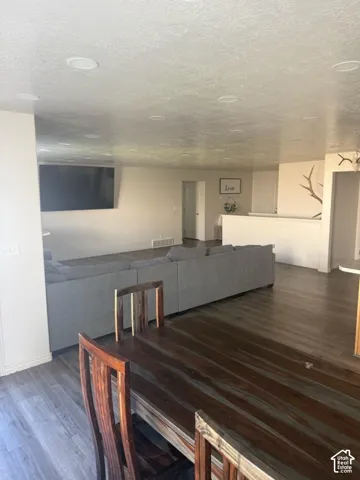 Recessed lighting, wood-finish flooring, and a partial wall with a cap