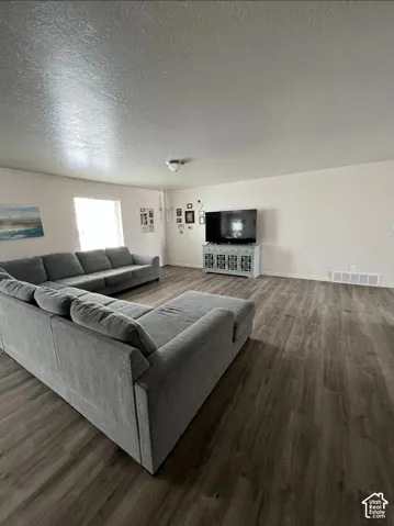 Wood-finish flooring throughout, a single flush-mount ceiling light fixture, and a window providing natural light