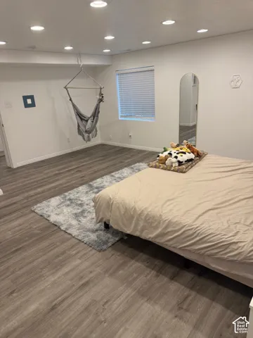 Recessed ceiling lighting, wood-finish flooring, and a window with blinds