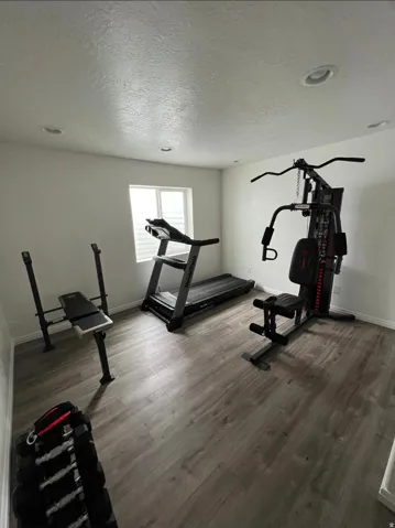 Recessed lighting, wood-finish flooring, and a window with blinds