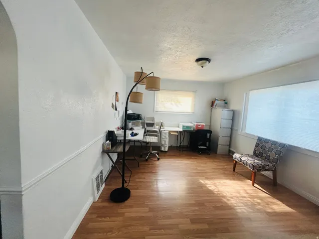 Wood-finish flooring throughout, white walls, and a recessed window