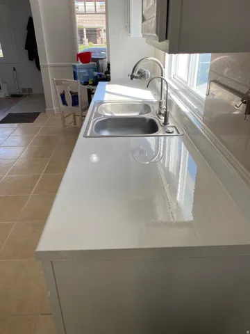 Dual basin stainless steel sink with a polished chrome faucet, set into a light-toned countertop