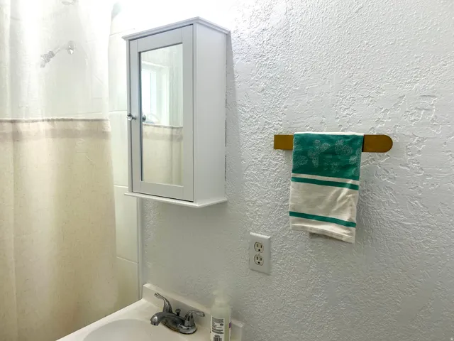 Wall-mounted medicine cabinet with a mirrored door and lower shelf