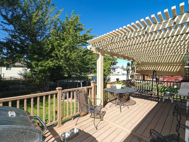 Expansive wood deck with a slatted pergola, offering a partially shaded outdoor living area