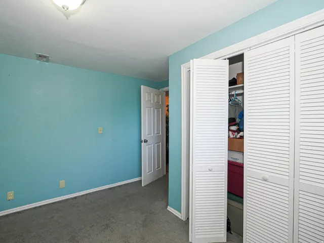 Recessed lighting with a flush-mount fixture, painted walls, carpeted flooring, and louvered bifold closet doors