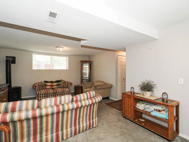 Recessed lighting, wood-burning stove, flush-mount ceiling light, window with blinds, interior door