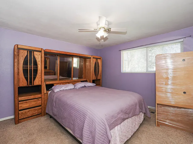 Carpeted flooring, window with blinds, ceiling fan with integrated lighting, and painted walls