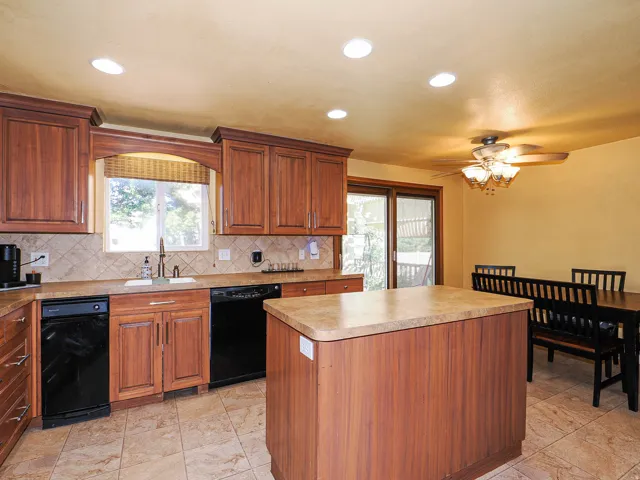 Kitchen featuring wood cabinetry, a center island with countertop, tile flooring, and recessed lighting