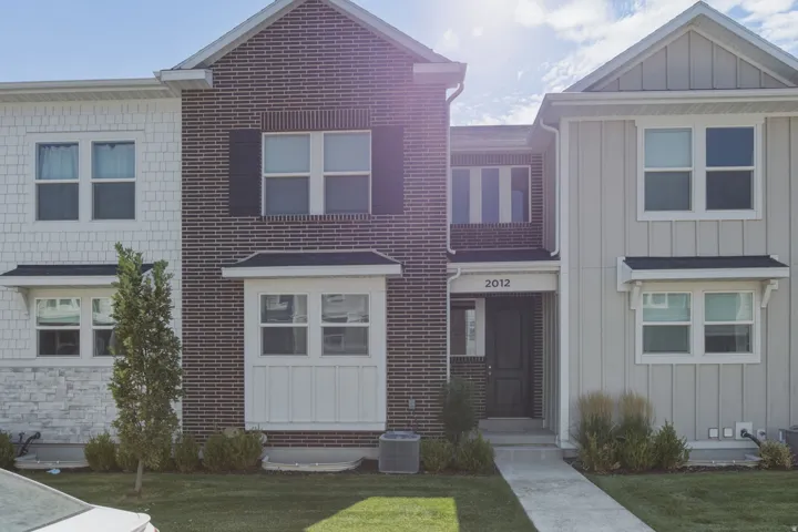 Townhome exterior featuring a brick facade and a prominent front entrance
