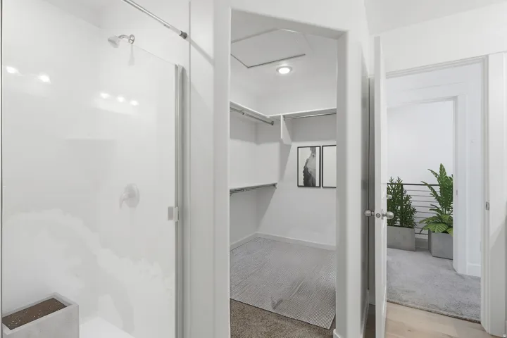 Shower with a clear glass enclosure and overhead lighting