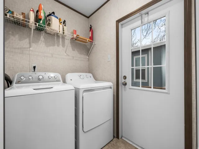 Laundry area with a wire shelving unit, textured wall covering, and a white exterior door with window panes
