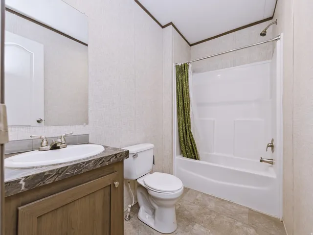 Bathroom featuring a single vanity with a laminate countertop, a drop-in sink, and a chrome faucet