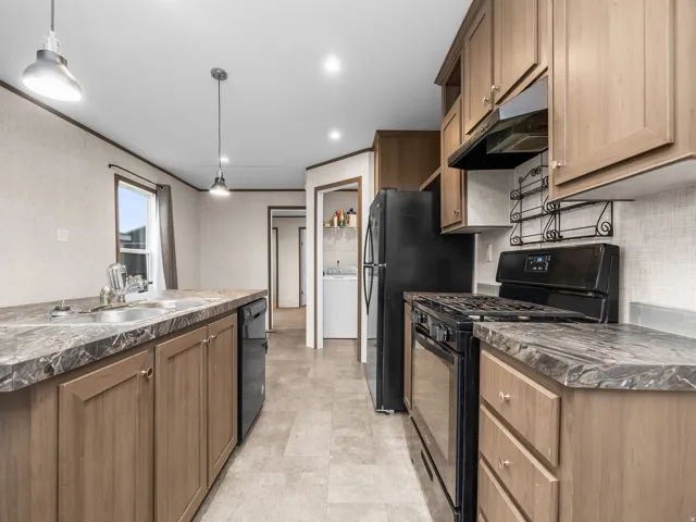 Kitchen featuring wood-finish cabinetry, dark countertops, and tile flooring