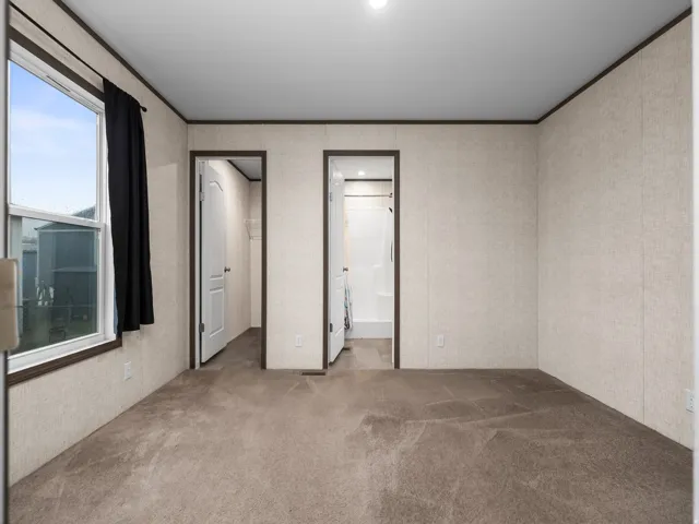 Neutral tone carpeting, light-textured wall panels, and two panel doors