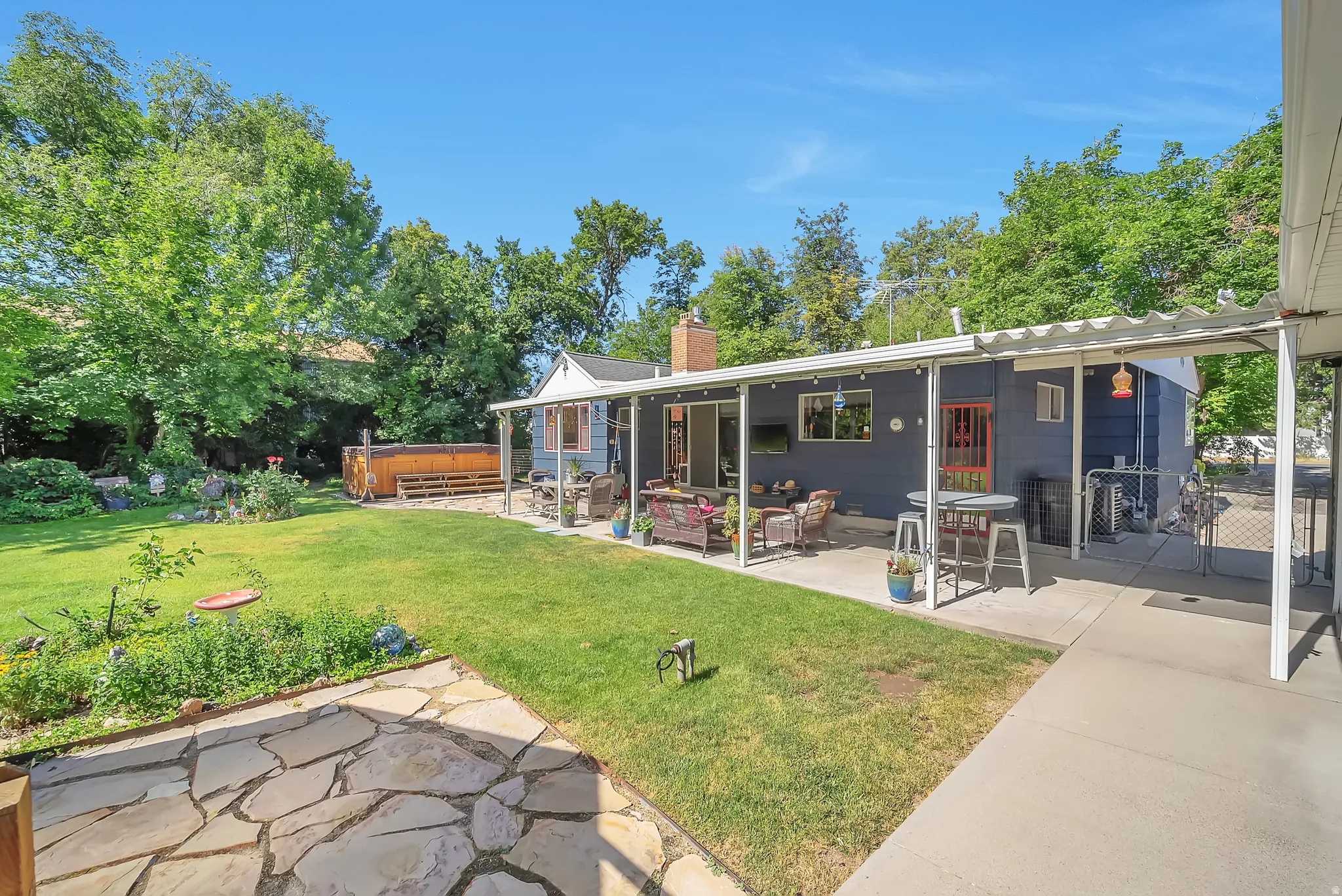 Expansive backyard featuring a covered patio, a flagstone patio, and a hot tub deck