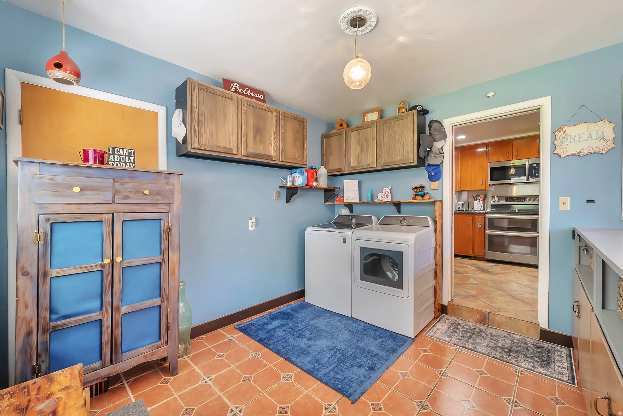 Tiled flooring, upper cabinetry, built-in shelving, and a decorative light fixture