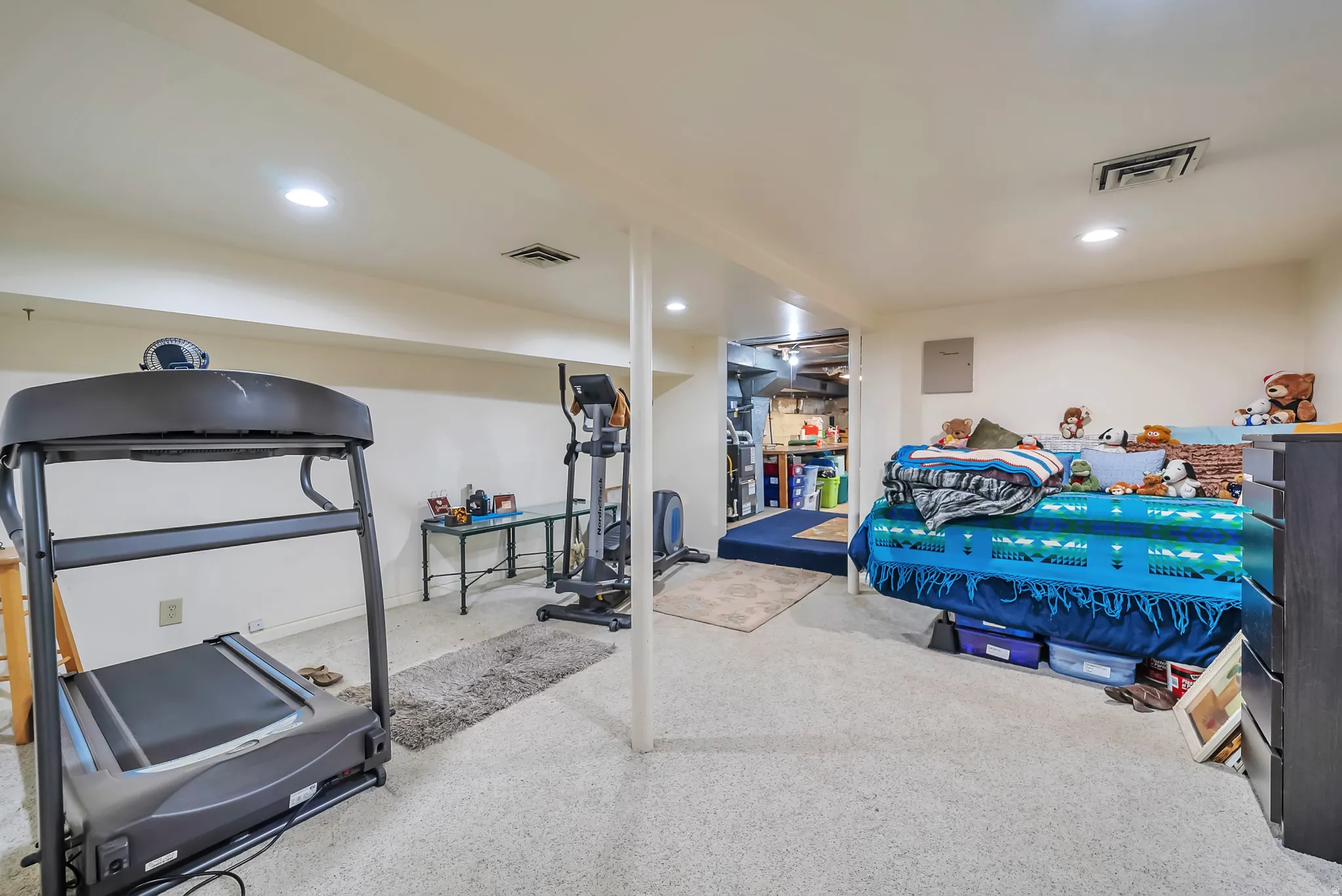 Recessed ceiling lighting, carpeted flooring, and exposed support columns